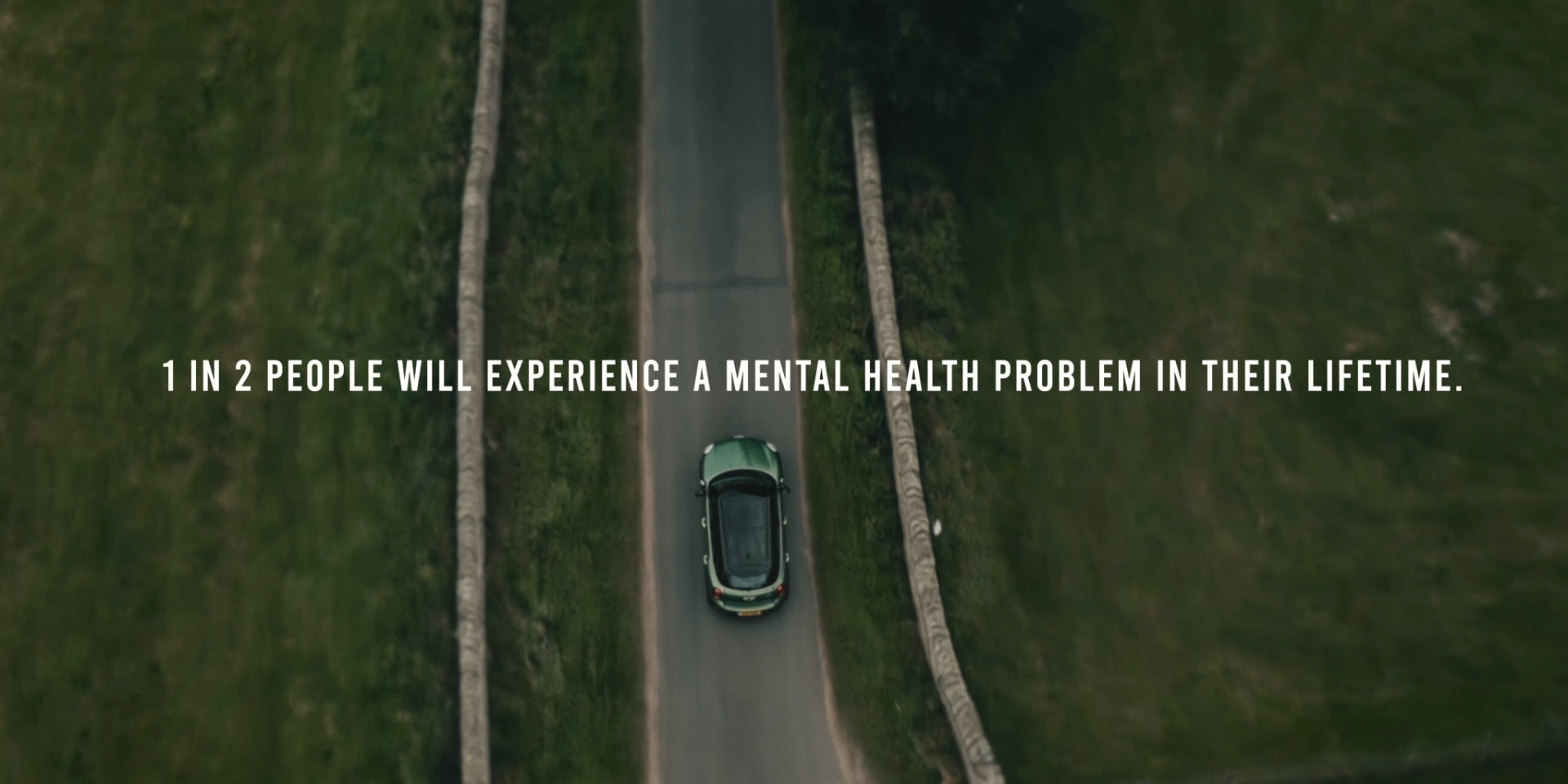 Aerial view of a car on a road with the text: 1 in 2 people will experience a mental health problem in their lifetime